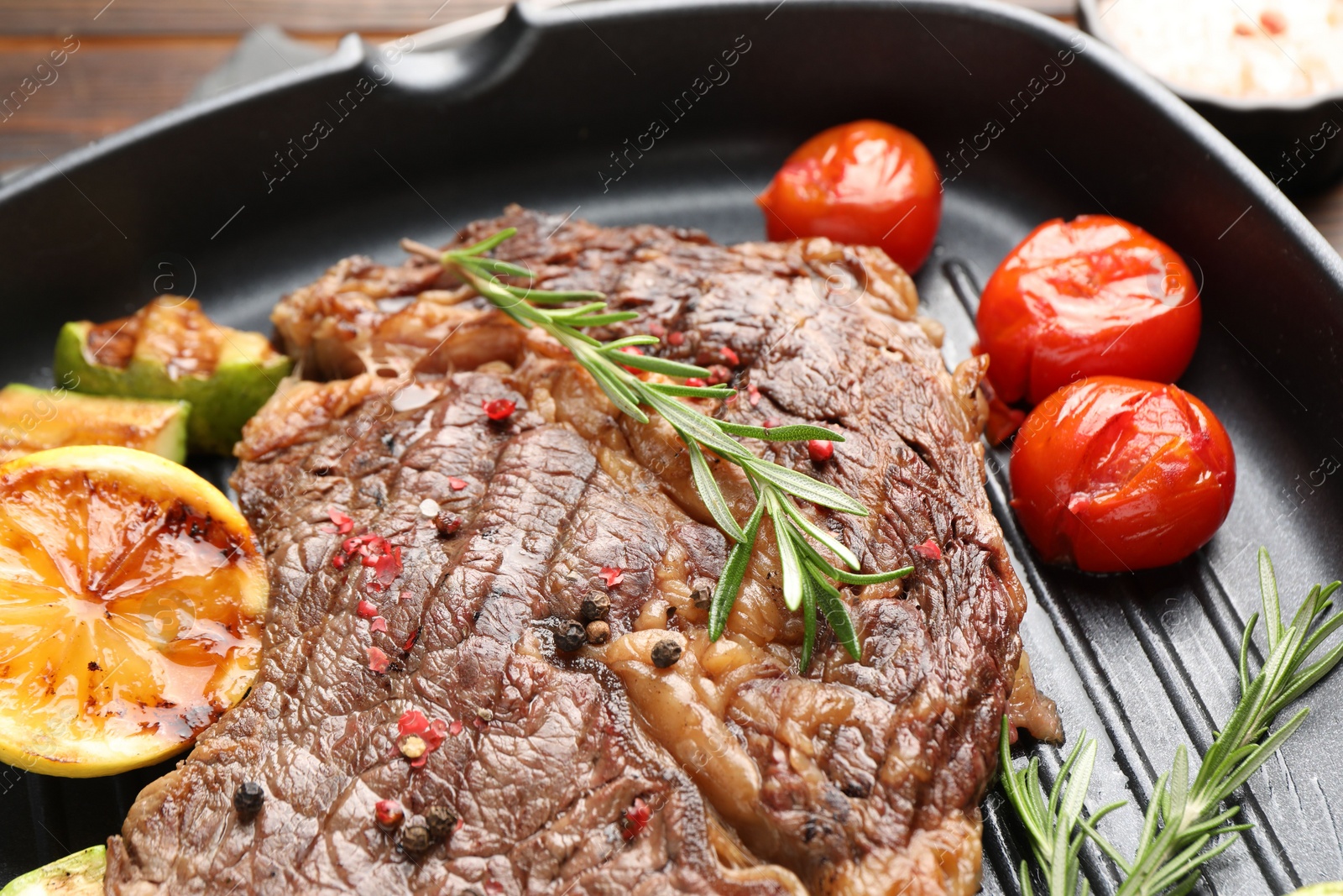 Photo of Delicious grilled beef steak and vegetables in frying pan, closeup