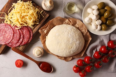 Pizza dough and products on gray textured table, flat lay