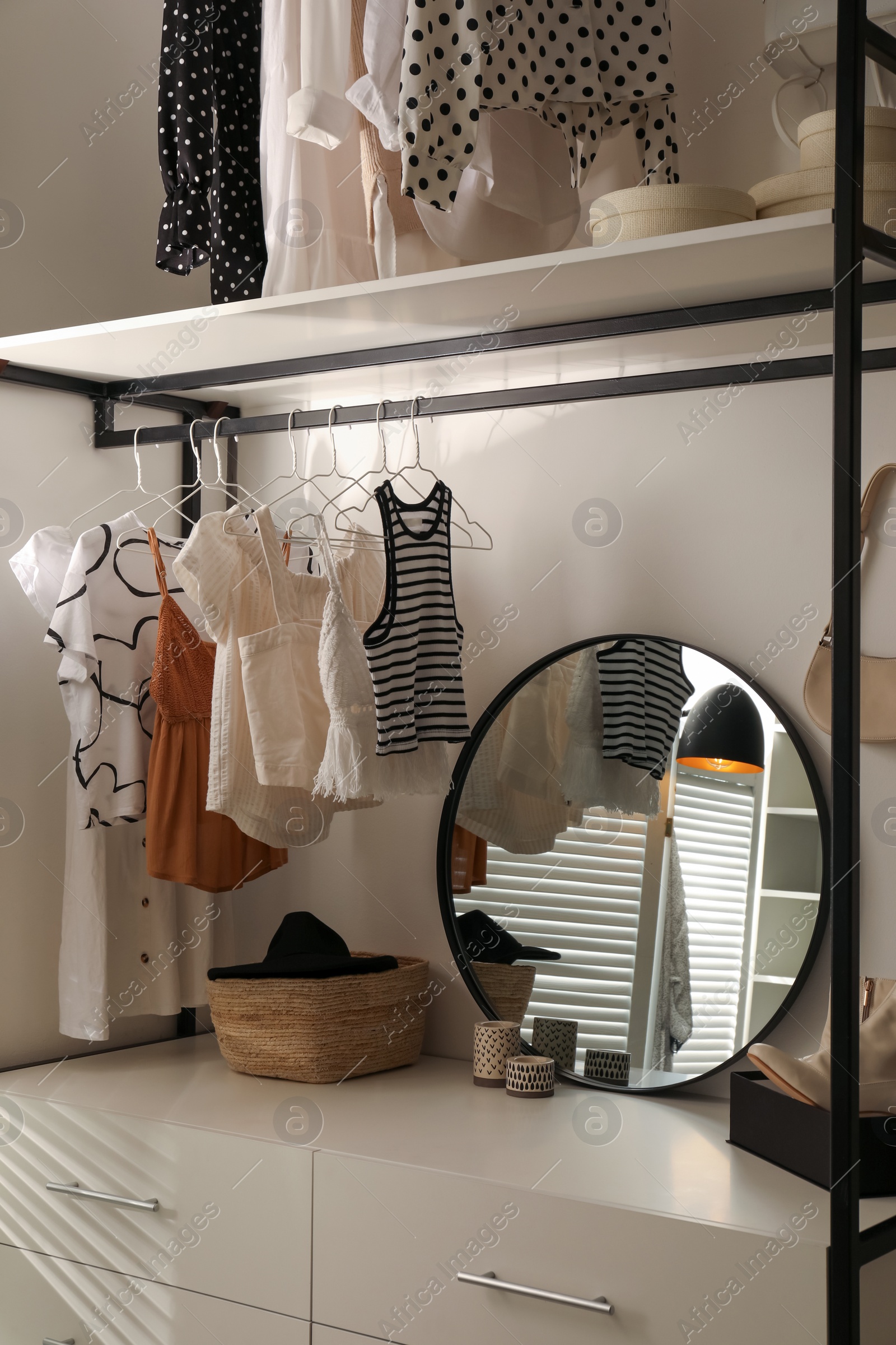 Photo of Storage rack with stylish women's clothes and accessories indoors