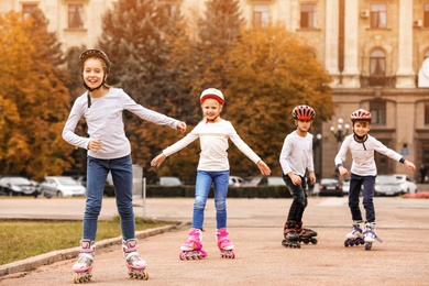 Photo of Happy children roller skating on city street