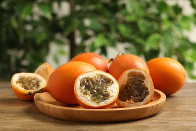 Photo of Delicious ripe granadillas on wooden table. Exotic fruit