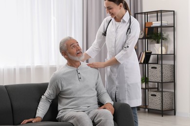 Photo of Young healthcare worker and senior man indoors