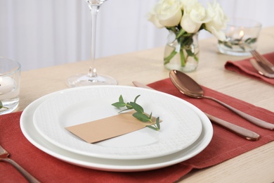 Photo of Elegant festive table setting with blank card in restaurant