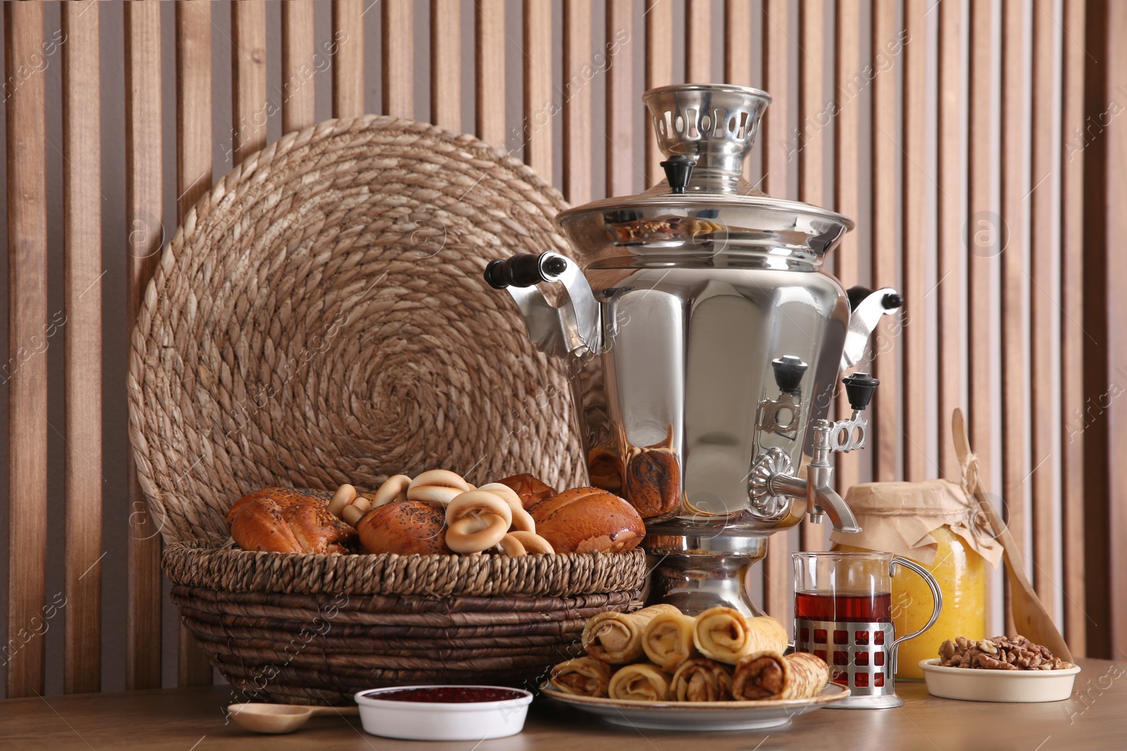 Photo of Traditional Russian samovar with treats on wooden table