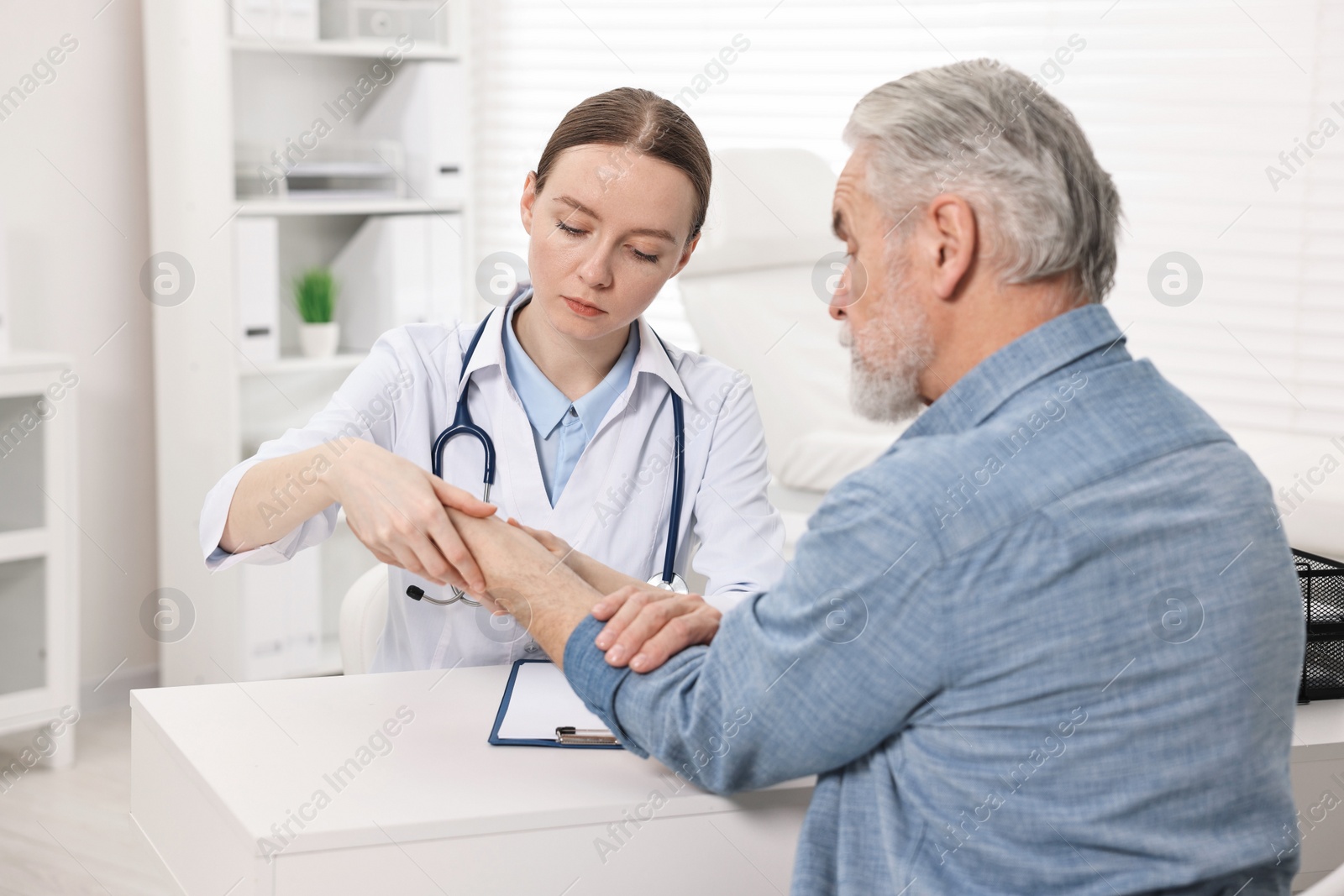 Photo of Arthritis symptoms. Doctor examining patient's wrist in hospital