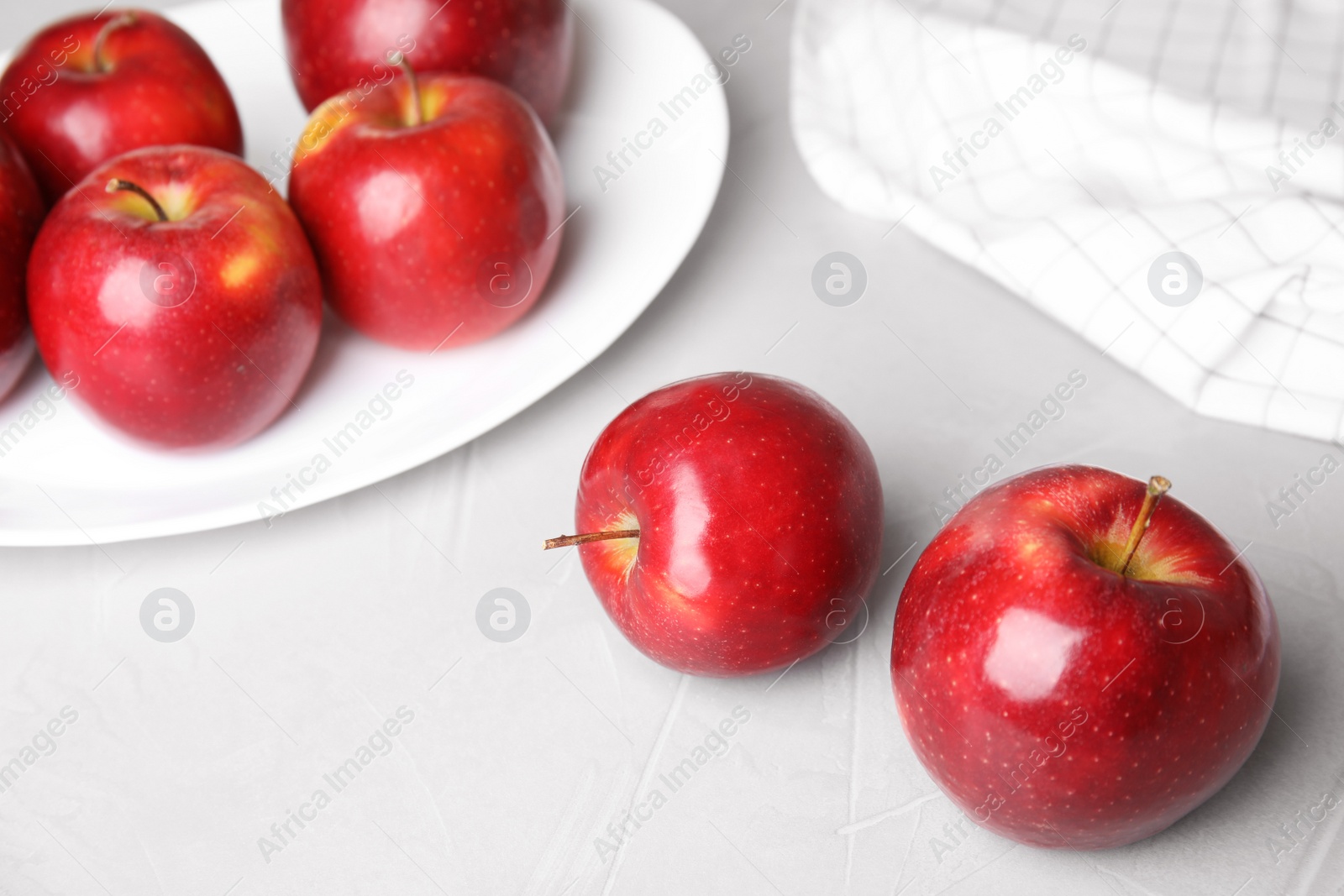 Photo of Ripe juicy red apples on light table