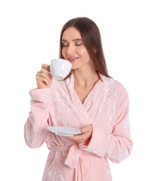 Young woman in bathrobe with cup of drink on white background