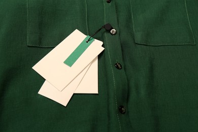 Blank white tags on green shirt. Space for text