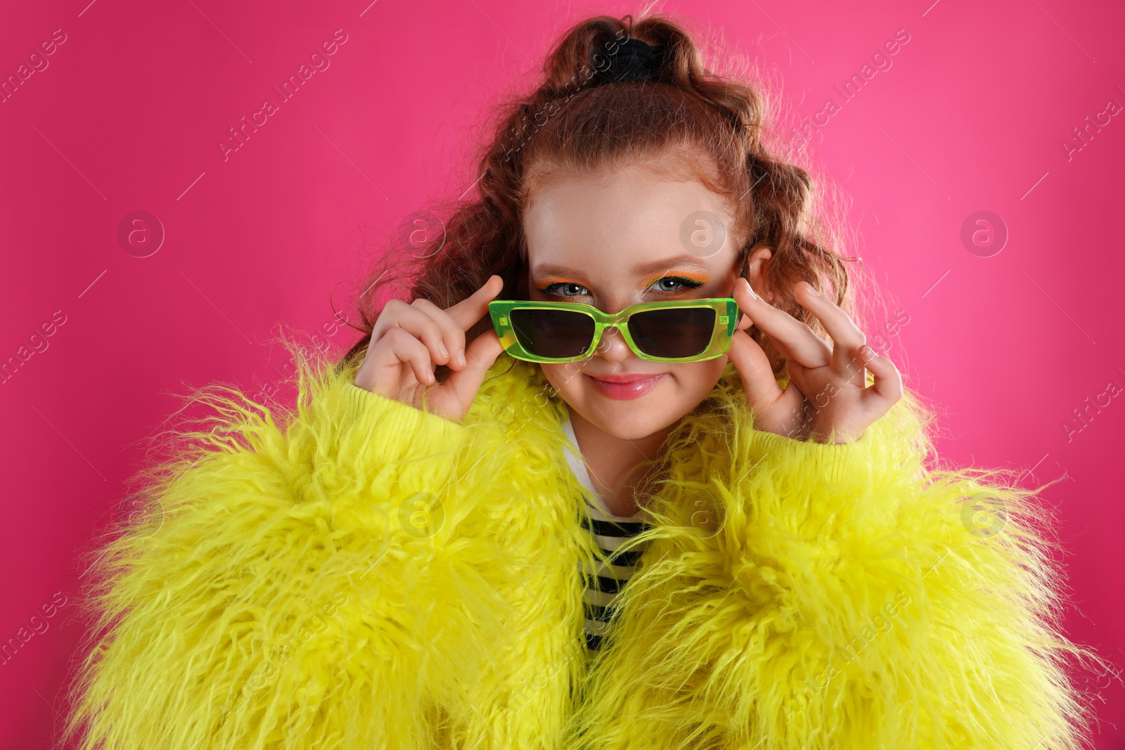 Photo of Cute indie girl with sunglasses on pink background