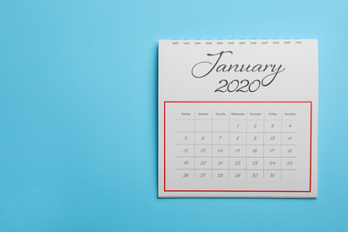 Photo of January 2020 calendar on light blue background, top view. Space for text