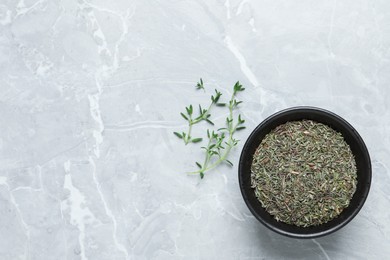 Bowl with dried thyme and fresh twigs on light table, flat lay. Space for text