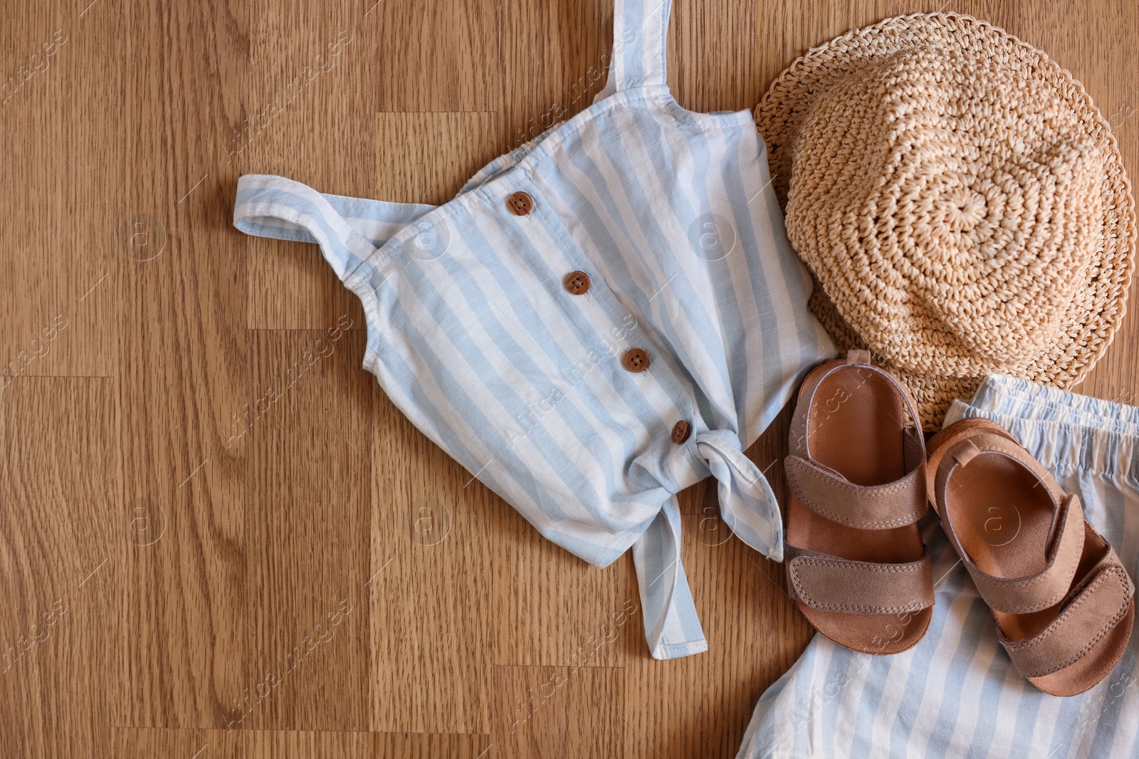 Photo of Stylish child clothes, shoes and hat on wooden background, flat lay. Space for text
