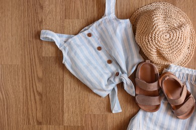 Photo of Stylish child clothes, shoes and hat on wooden background, flat lay. Space for text