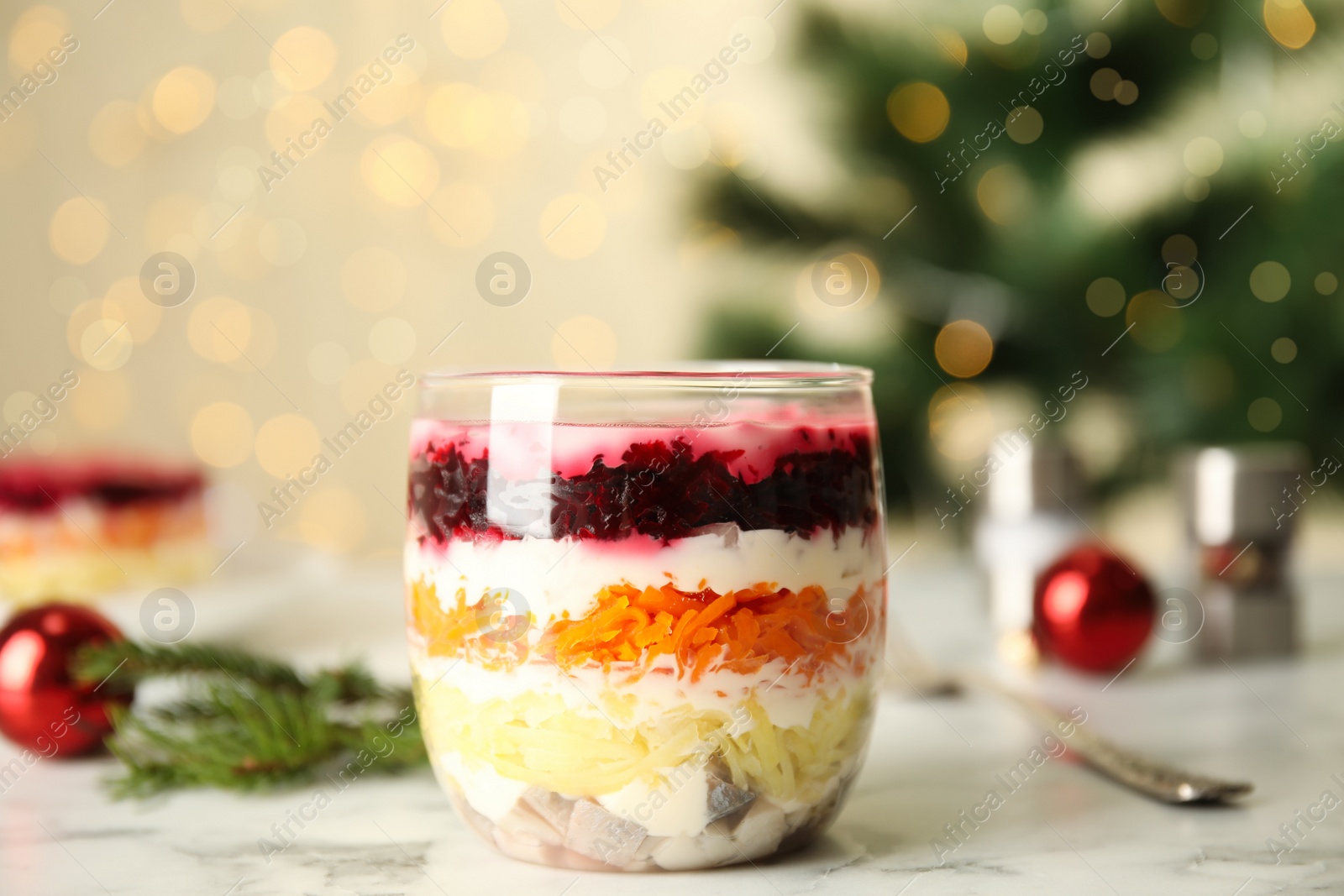 Photo of Herring under fur coat served on white marble table, space for text. Traditional russian salad