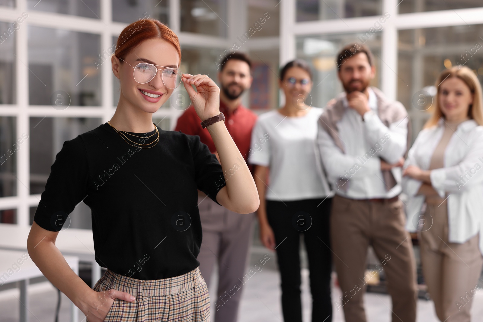 Photo of Portrait of happy businesswoman and her team in office