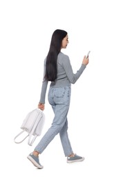 Photo of Young woman using smartphone while walking on white background