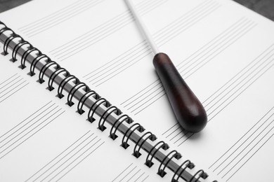 Photo of Conductor's baton on sheet music book, closeup