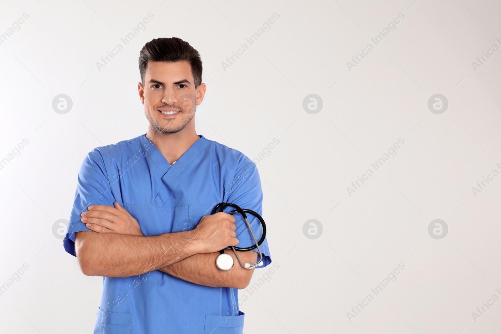 Photo of Doctor with stethoscope on light grey background. Space for text