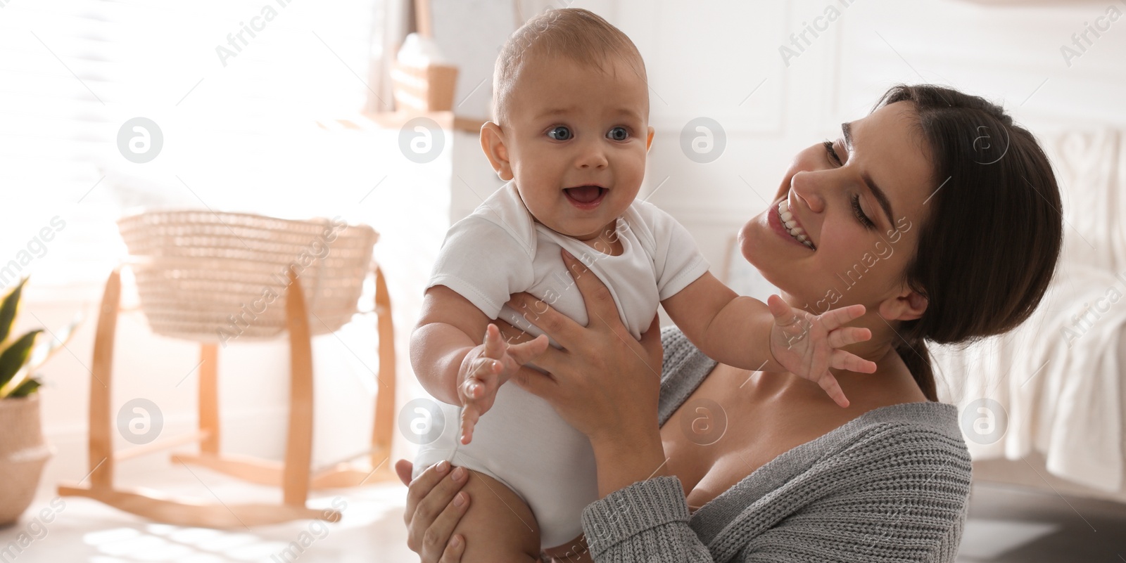 Image of Happy young mother with her cute baby at home, space for text. Banner design 