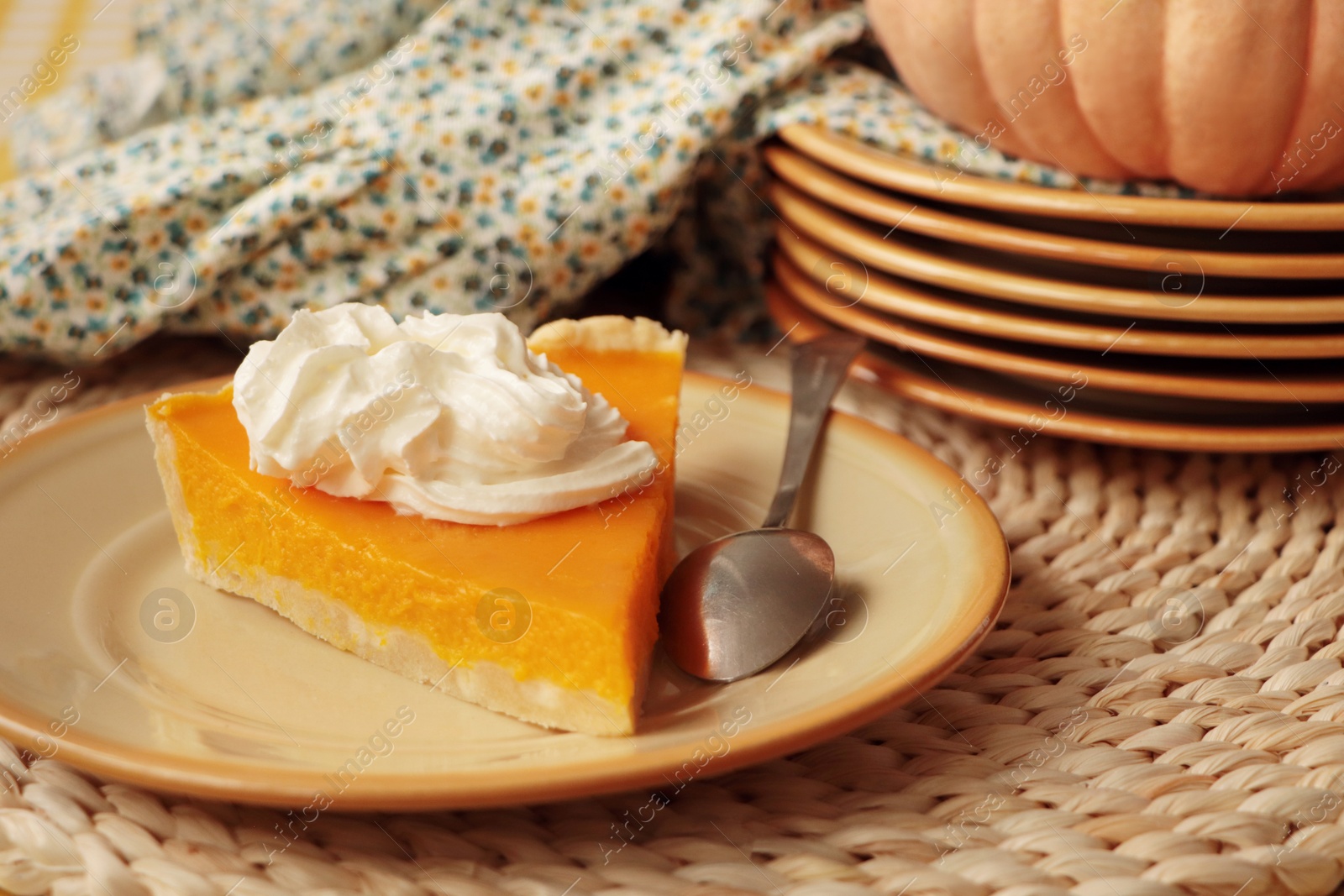 Photo of Piece of fresh homemade pumpkin pie with whipped cream on table