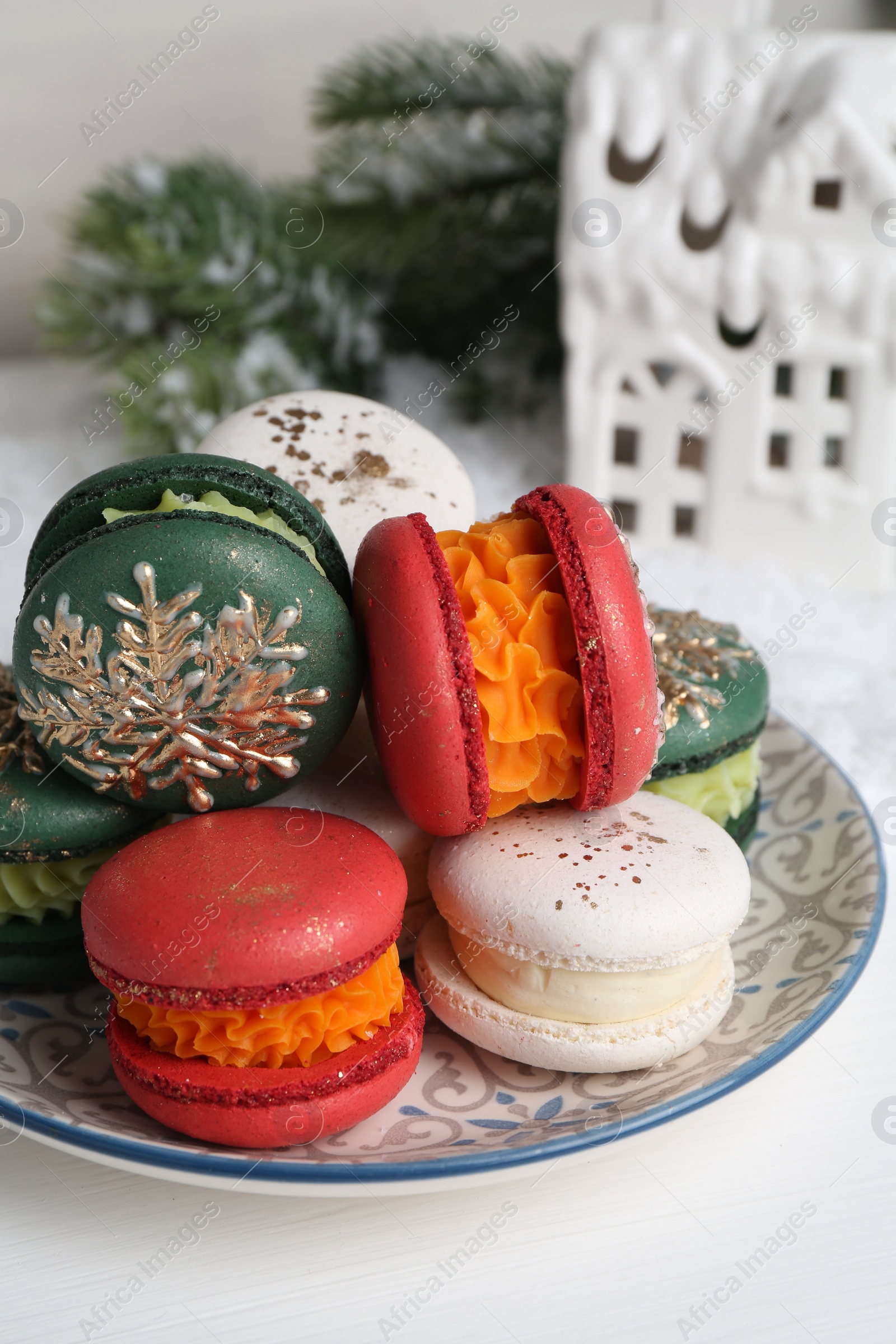 Photo of Different decorated Christmas macarons on white table, closeup