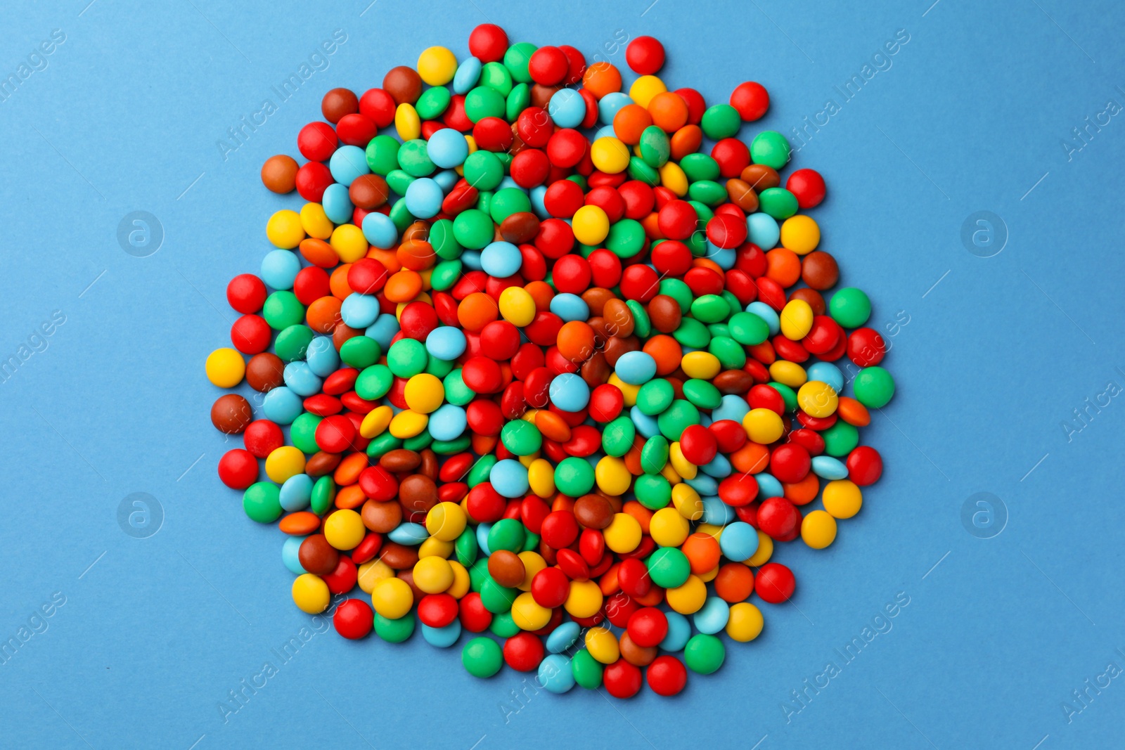 Photo of Tasty colorful candies on blue background, flat lay