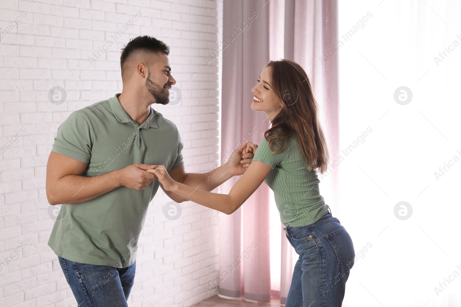 Photo of Lovely young couple dancing together at home