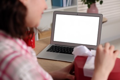 Valentine's day celebration in long distance relationship. Woman opening gift from her boyfriend indoors, closeup