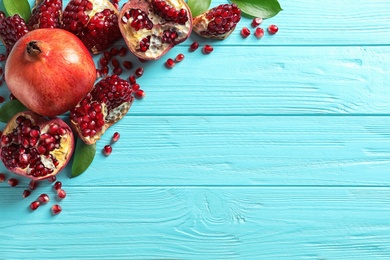 Photo of Composition with ripe pomegranates and space for text on wooden background, flat lay