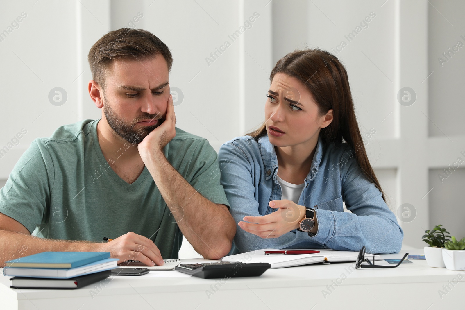 Photo of Young couple discussing family budget at home