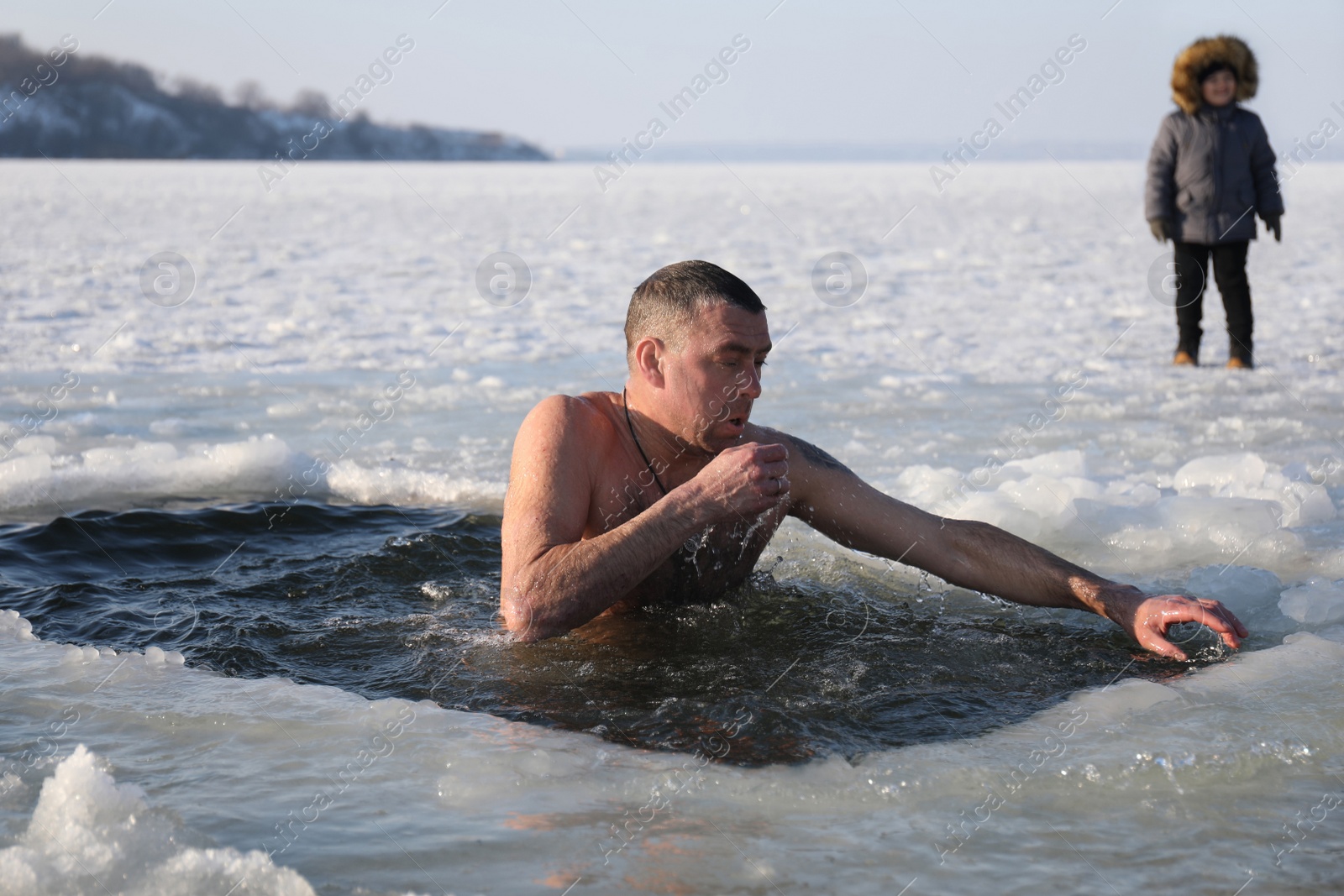 Photo of MYKOLAIV, UKRAINE - JANUARY 06, 2021: Man immersing in icy water on winter day