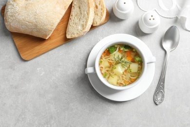 Photo of Dish of fresh homemade vegetable soup served on light grey table, flat lay. Space for text