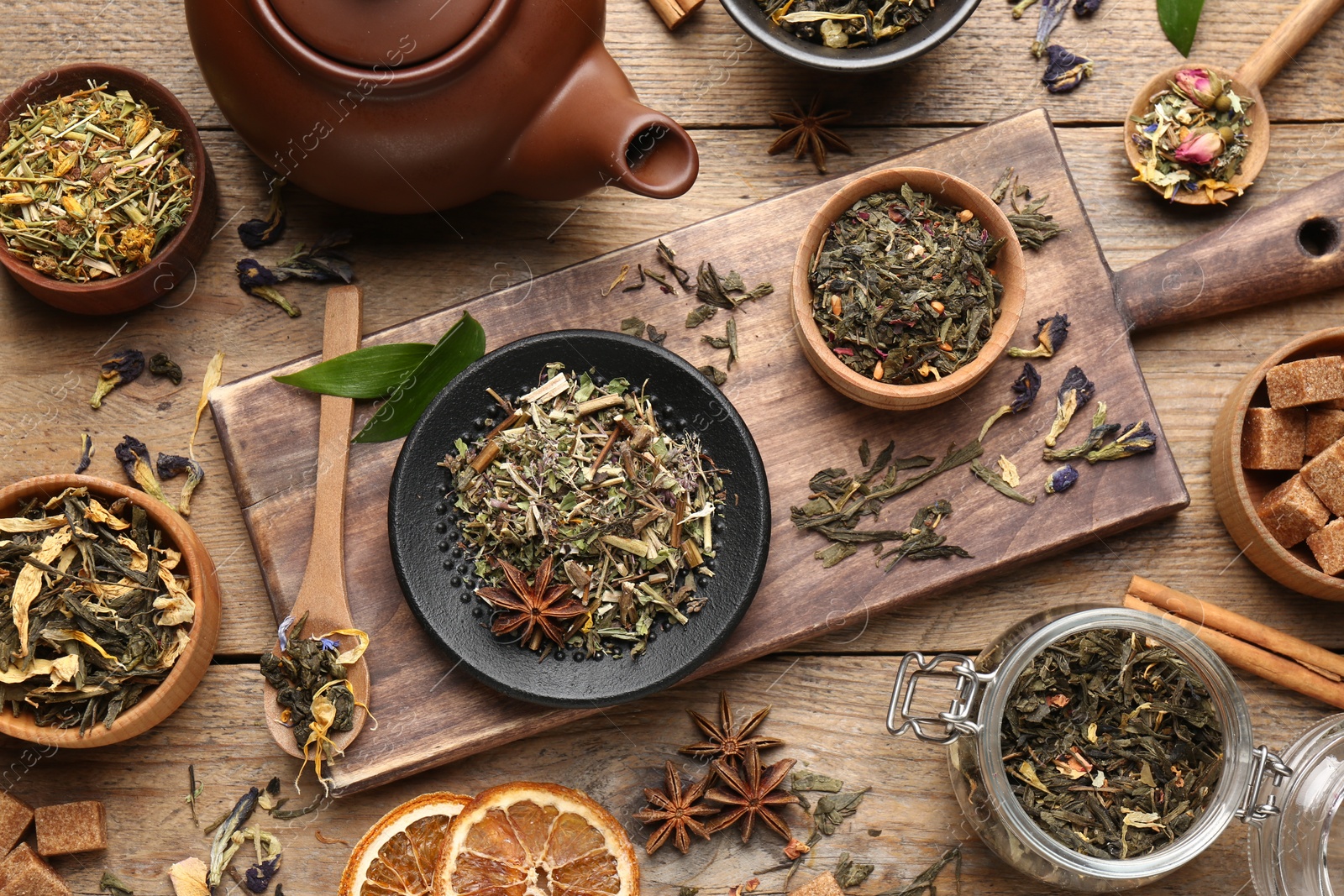 Photo of Flat lay composition with different dry teas on wooden table