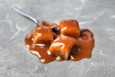 Photo of Delicious candies with caramel sauce on table