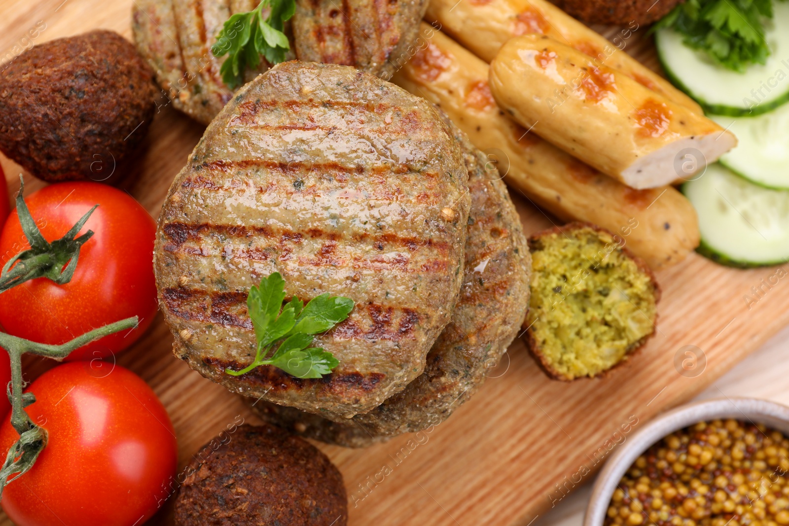 Photo of Different tasty vegan meat products and fresh vegetables on wooden board, flat lay