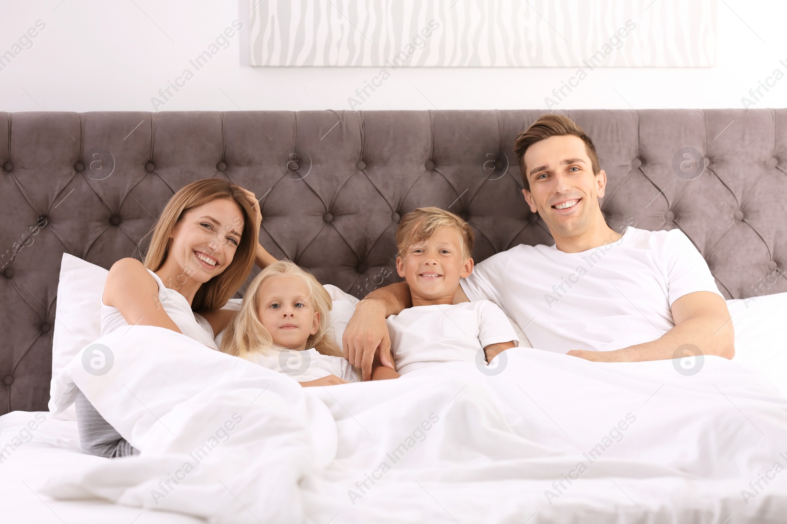 Photo of Happy family in bed with pillows at home. Weekend morning