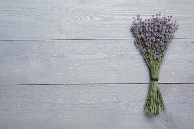 Dried lavender flowers on grey wooden table, top view. Space for text