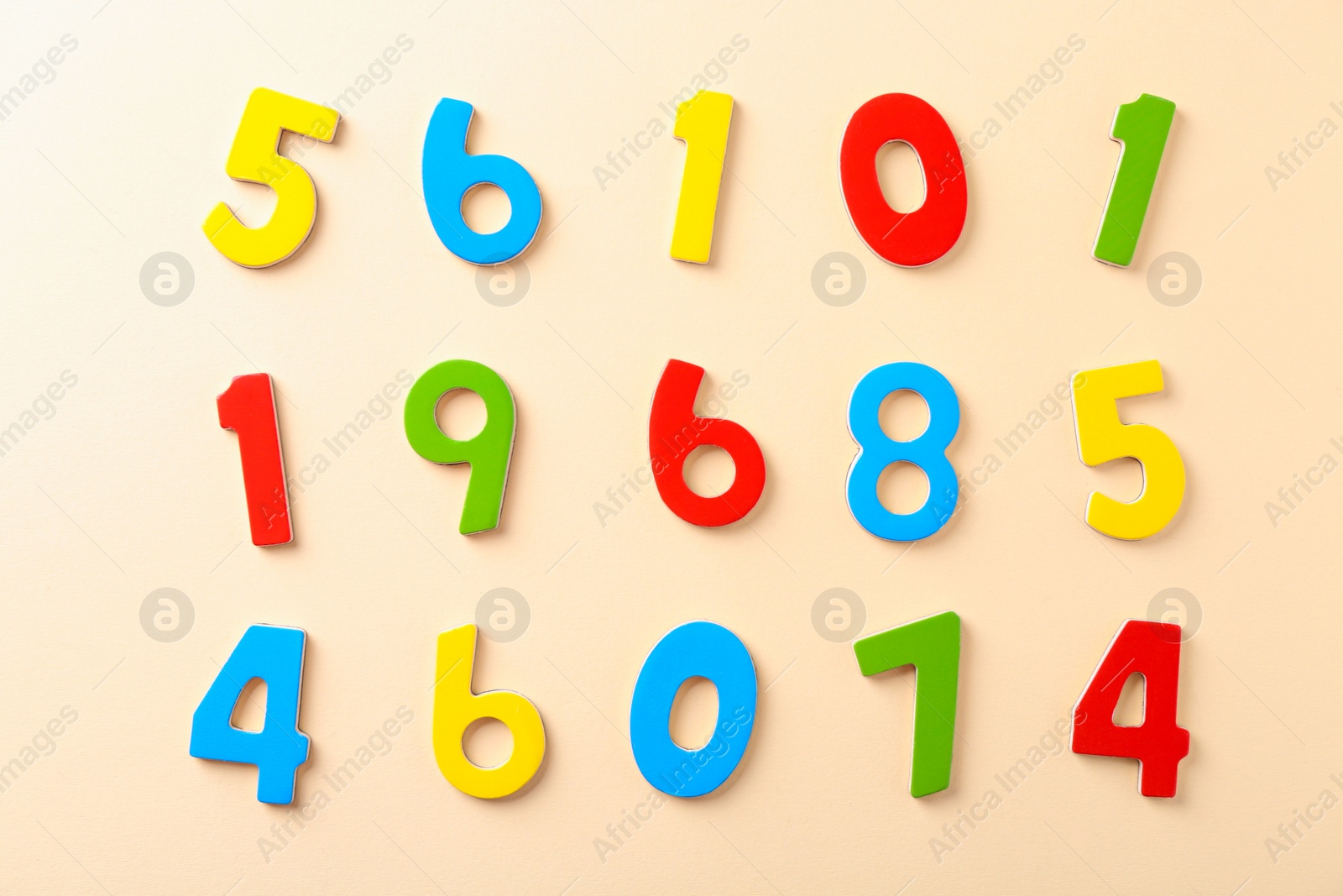 Photo of Colorful numbers on beige background, flat lay