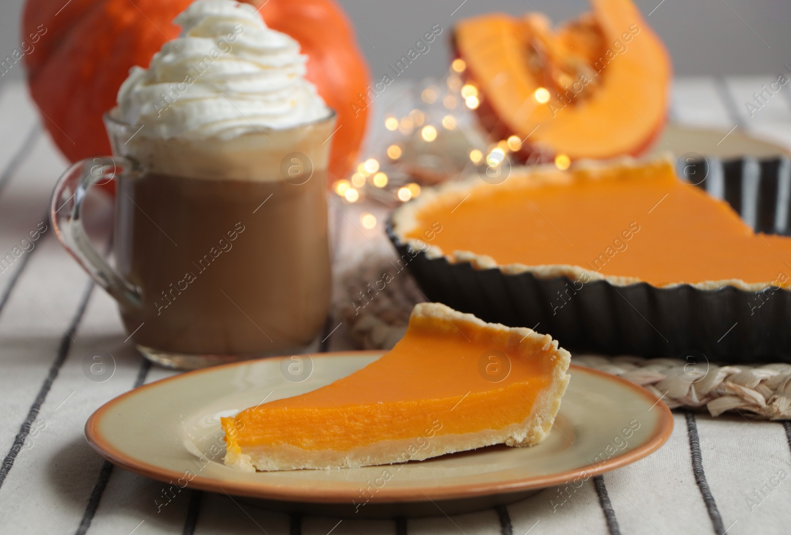 Photo of Fresh homemade pumpkin pie and cup of cocoa with whipped cream on table