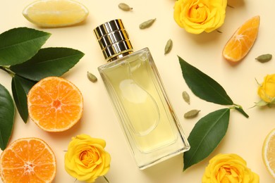 Photo of Flat lay composition with bottle of perfume and fresh citrus fruits on beige background