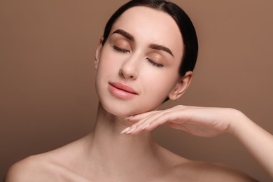 Photo of Portrait of beautiful young woman on brown background