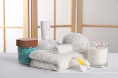 Spa composition with care products on white wooden table in room