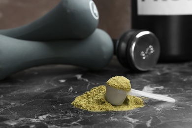 Measuring spoon with hemp protein powder on table. Space for text