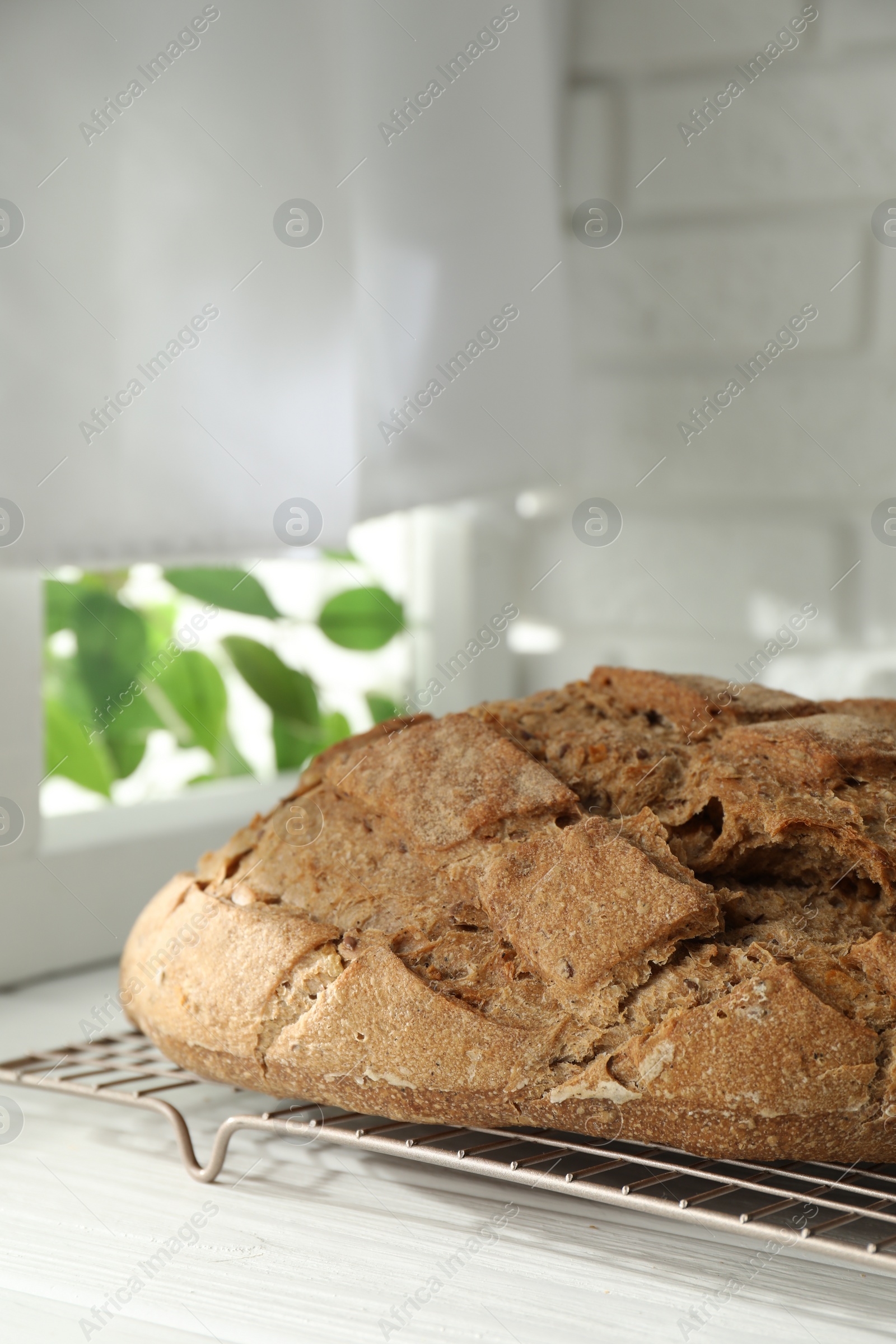 Photo of Freshly baked sourdough bread on white wooden table indoors