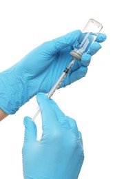 Doctor filling syringe with medication from glass vial on white background, closeup