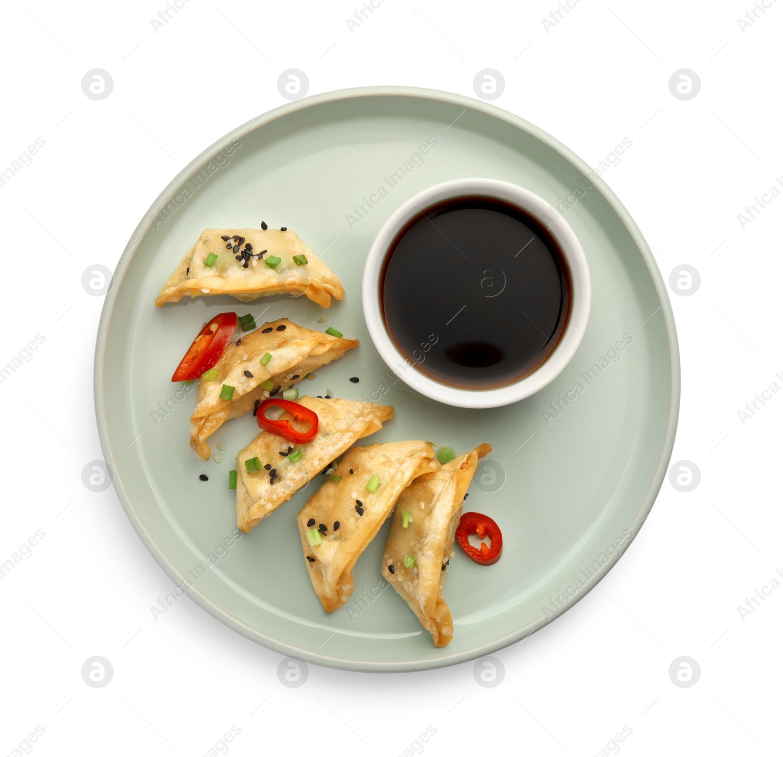 Photo of Delicious gyoza (asian dumplings) with soy sauce, pepper, onion and sesame isolated on white, top view