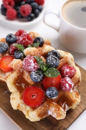 Photo of Delicious Belgian waffles with fresh berries on white table, closeup
