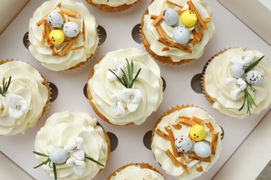 Photo of Tasty Easter cupcakes in box, top view