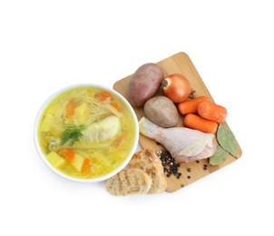 Photo of Delicious chicken broth in bowl and ingredients isolated on white, top view