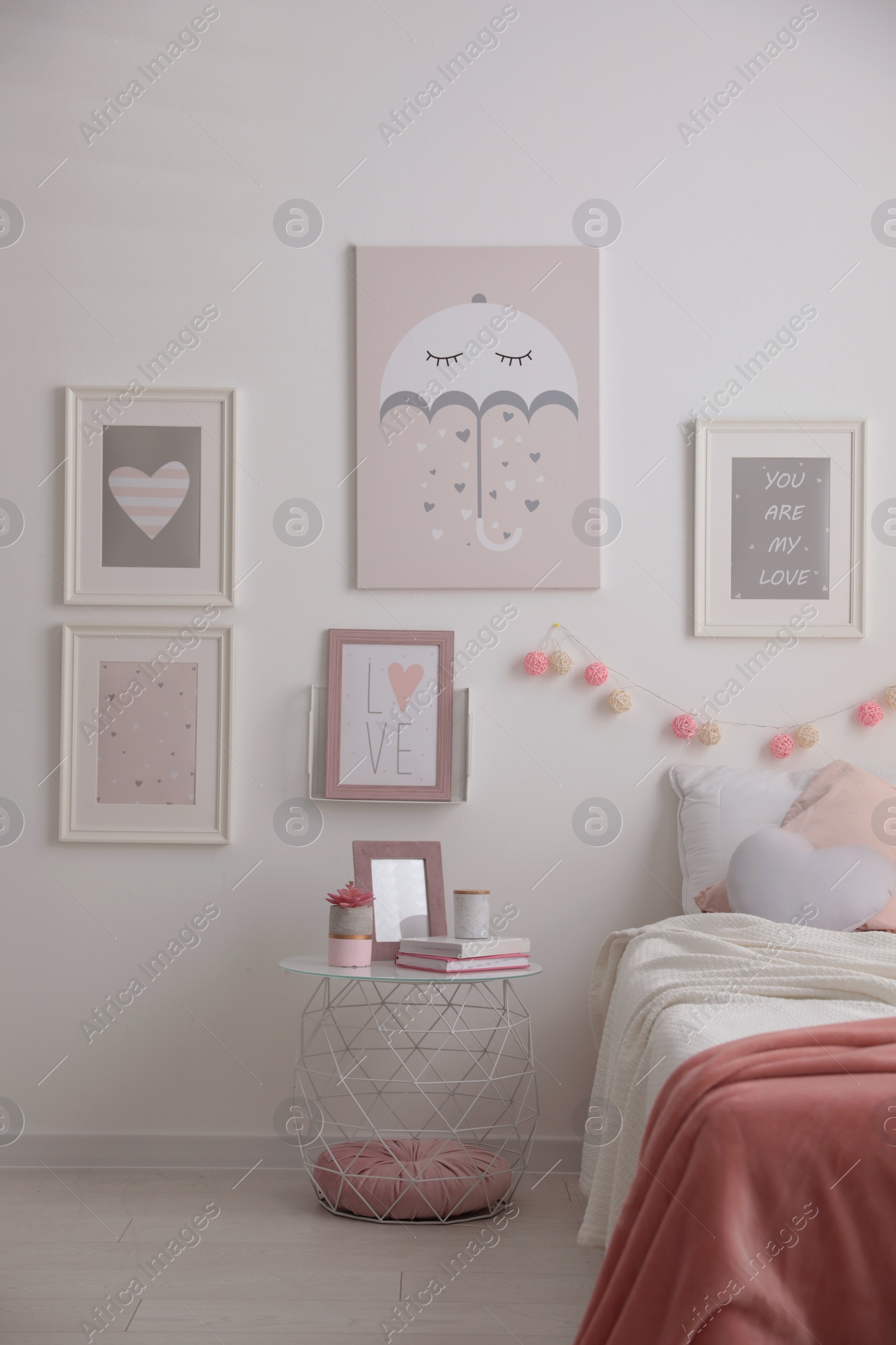 Photo of Stylish child's room interior with beautiful pictures and comfortable bed